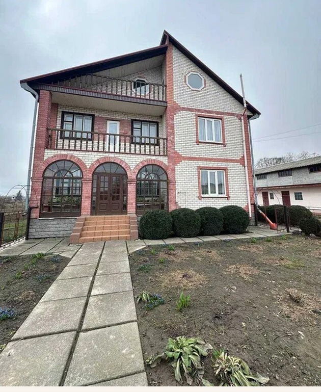 House exterior photo with sky and landscaping enhancement, before editing